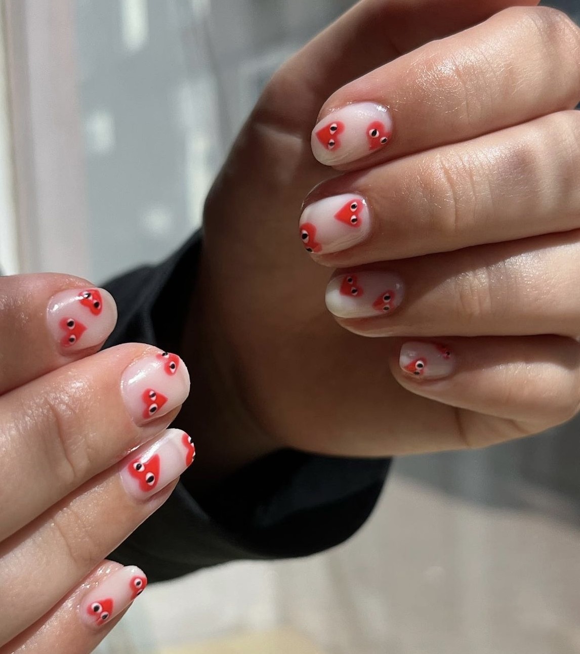 Melkwitte nagels met rode hartjes met oogjes
